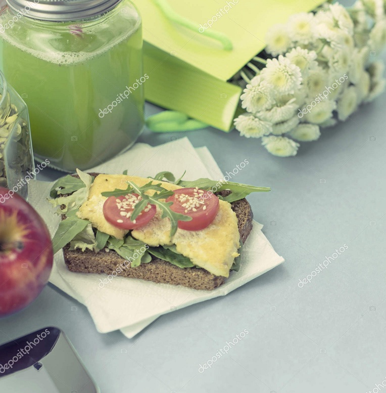 Healthy vegetarian Breakfast. Sandwich grain bread tofu cheese, detox smoothie, pumpkin seeds, cherry tomatoes, natural flowers, blue background, notebook. Lunch box with soup for lunch